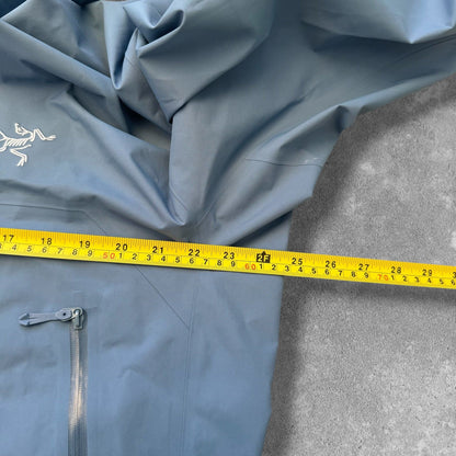 Arc'teryx blue Gore-Tex jacket with logo, fully seam-sealed, premium hardshell design.